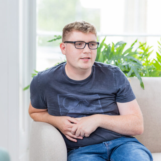 Photo of Dan Jacques, sitting on a sofa in the Barnwood Welcome area.