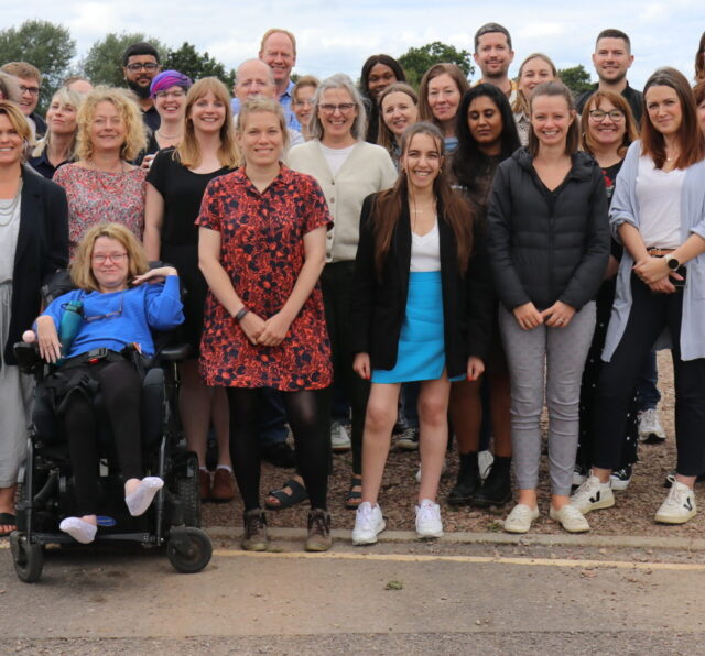 Photo shows a large group of Barnwood Trust staff posing for the camera in a group.